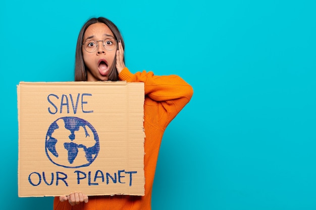 Joven latina con el tablero de salvar nuestro planeta