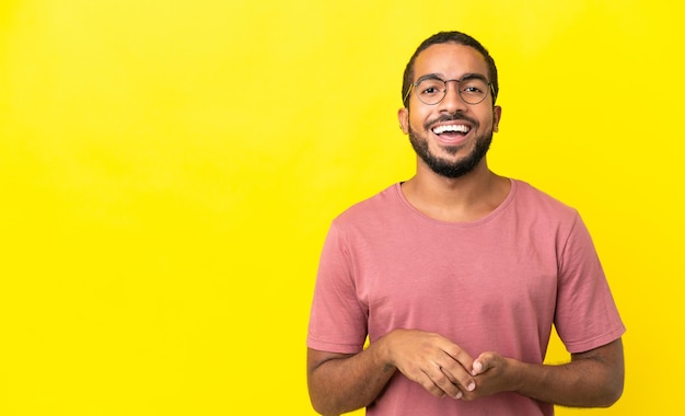 Joven latino aislado de fondo amarillo riendo