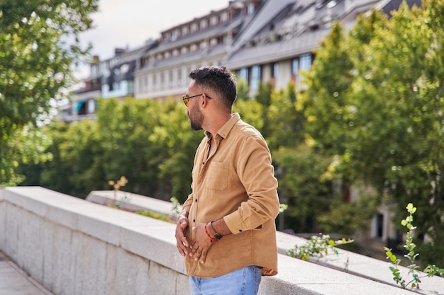 Joven latino esperando en la ciudad