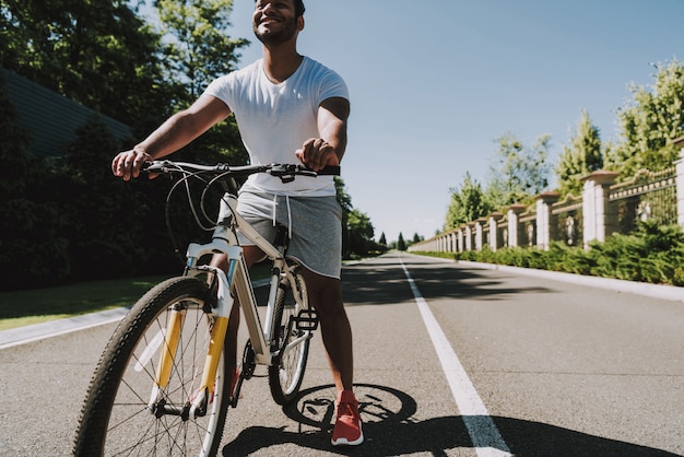 Joven latino está montando una bicicleta. Carretera Vacía