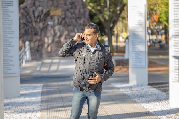 Joven latino hablando por teléfono móvil con espacio de copia