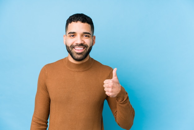 Joven latino sonriendo y levantando el pulgar