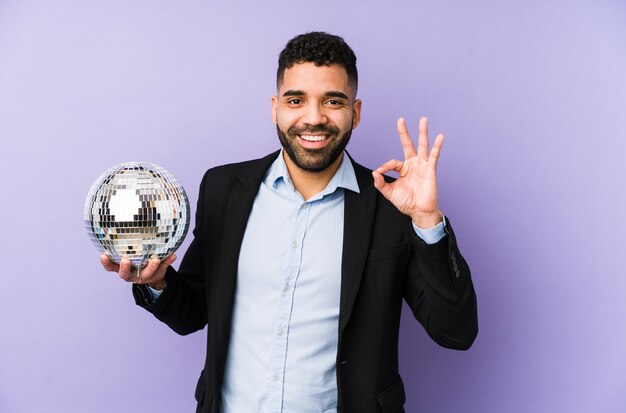 Joven latino sosteniendo una pelota de fiesta