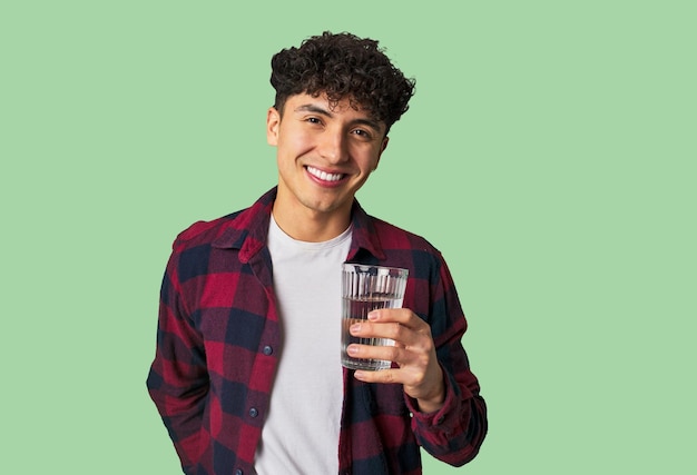 Joven latino sosteniendo un vaso de agua