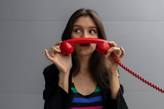 Joven latinoamericana con auriculares rojos y poses de actitud positiva con gestos divertidos Concepto de tecnología juvenil y vintage