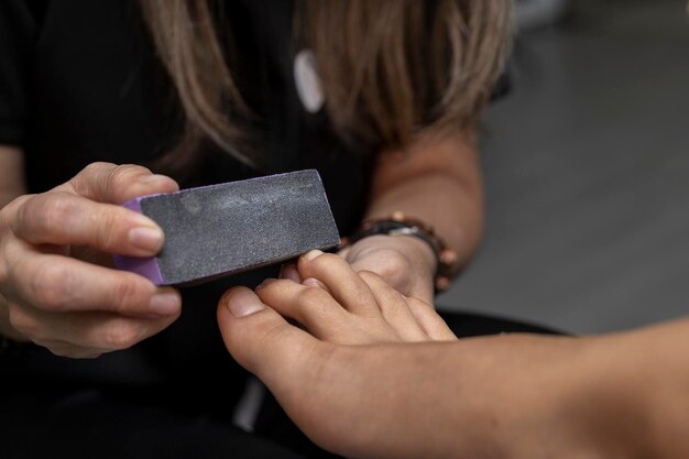 Joven latinoamericana recibiendo una pedicura profesional en un primer plano de un salón de belleza