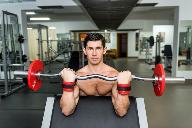 Joven levantando barra en el gimnasio