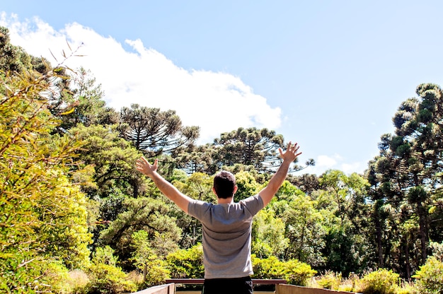 Joven levantando los brazos contemplando la naturaleza