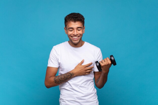 Foto joven levantando una campana riéndose a carcajadas de una broma hilarante, sintiéndose feliz y alegre, divirtiéndose