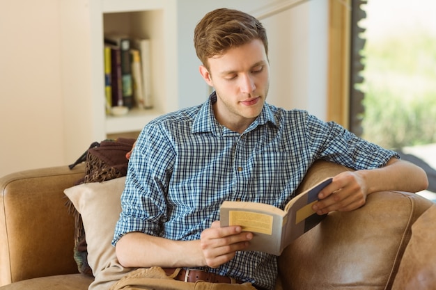 Joven leyendo en su sofá