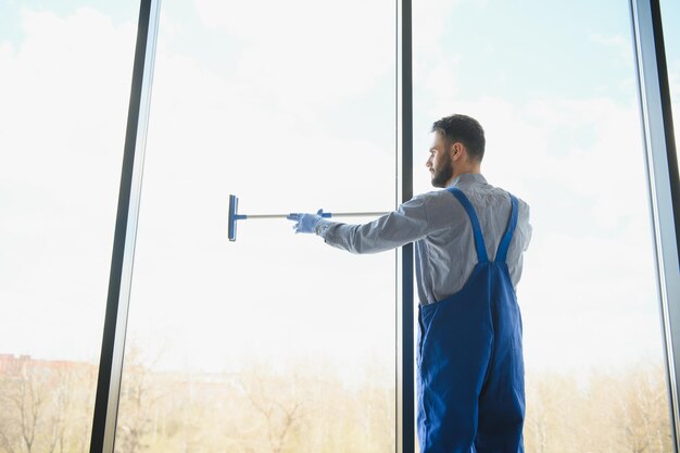 Foto joven limpiando la ventana en la oficina