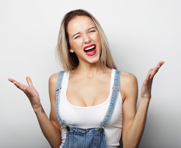 Joven linda chica rubia sonriente sobre fondo blanco.