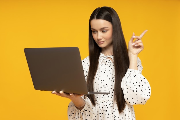 Una joven linda con una computadora portátil en las manos