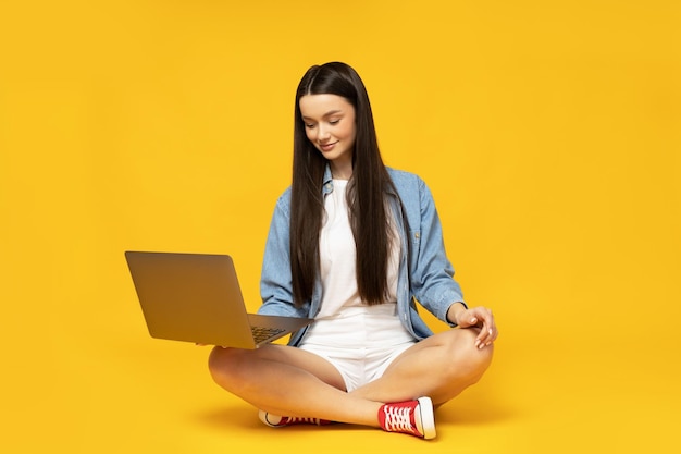 Una joven linda con una computadora portátil en las manos