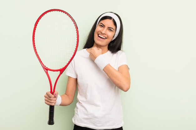 Joven linda mujer hispana que se siente feliz y enfrenta un desafío o celebra el concepto de tenis