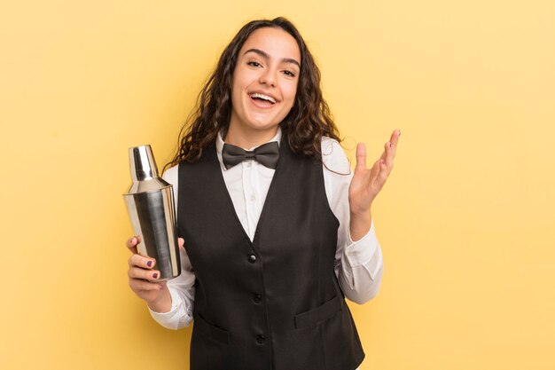 Joven linda mujer hispana que se siente feliz, sorprendida al darse cuenta de una solución o idea. barman y concepto de cóctel