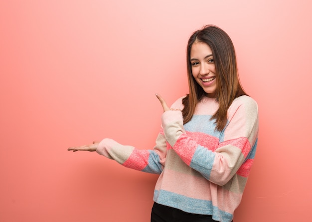 Joven linda mujer sosteniendo algo con la mano