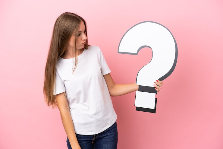 Foto joven lituana aislada de fondo rosa sosteniendo un icono de signo de interrogación