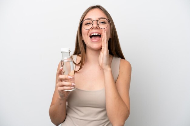 Foto joven lituana con una botella de agua aislada de fondo blanco gritando con la boca abierta