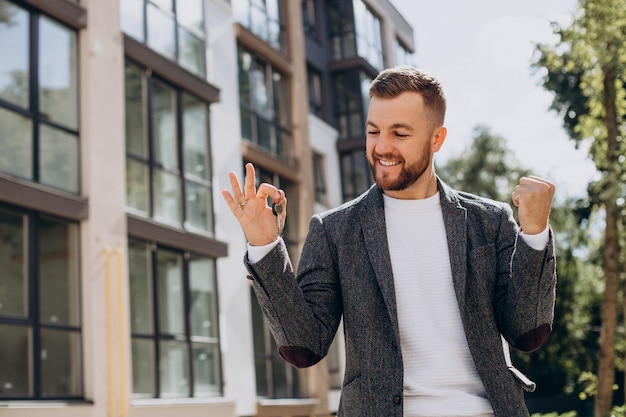 Joven con llaves acaba de comprar apartamento nuevo