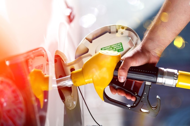 Foto joven, llene el tanque de diesel del automóvil después de terminar de llenar el diesel en la estación de servicio