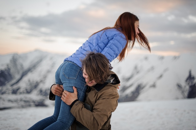 Joven llevando a su novia sobre los hombros