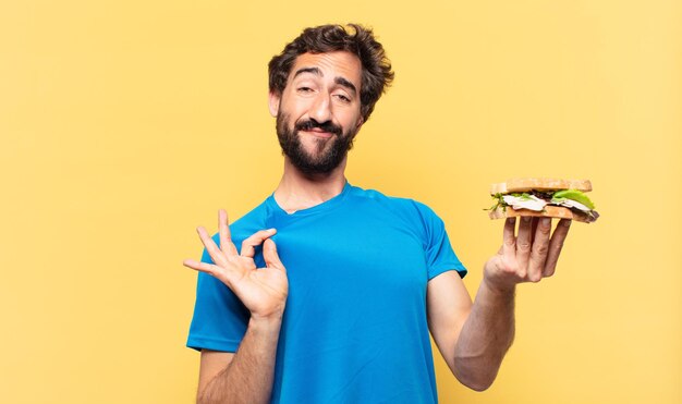 Joven loco atleta barbudo expresión feliz y concepto de dieta