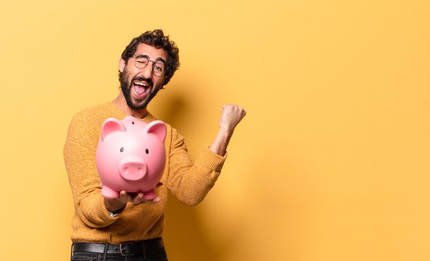 Joven loco barbudo con una alcancía