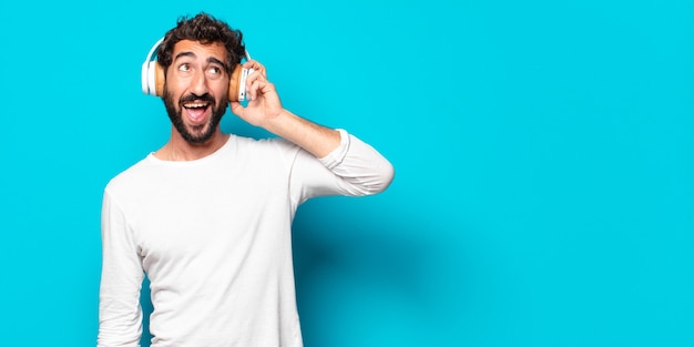 Joven loco barbudo con auriculares escuchando música