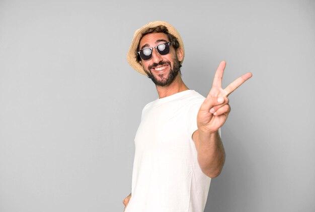 Joven loco barbudo y expresivo con gafas de sol y sombrero concepto de vacaciones