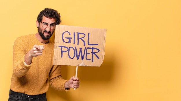 Joven loco barbudo sosteniendo una pancarta de poder femenino