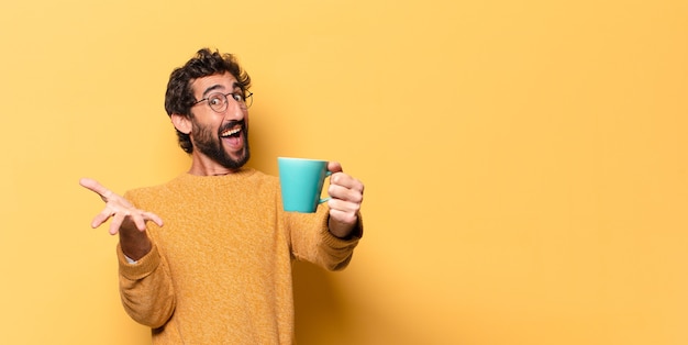 Joven loco barbudo con una taza de café