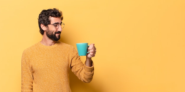 Joven loco barbudo con una taza de café