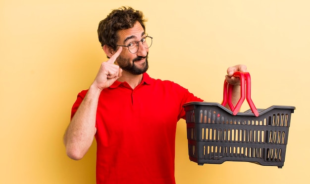 Joven loco con una cesta de la compra vacía