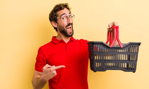 Joven loco con una cesta de la compra vacía