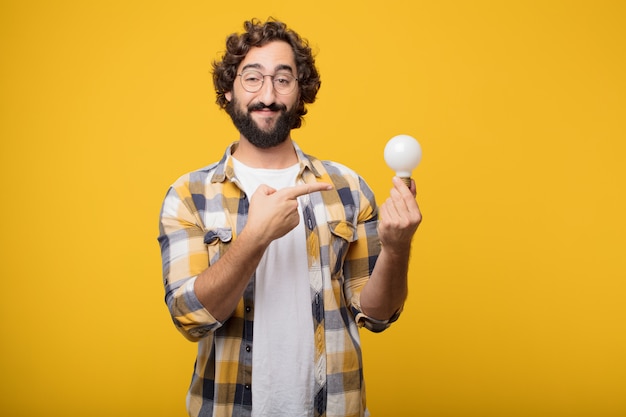 Joven loco loco tonto pose con una bombilla. idea o inspiración