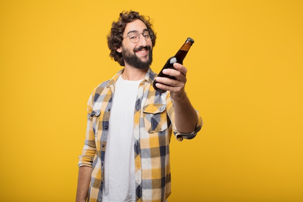 Joven loco loco tonto pose con una botella de cerveza.