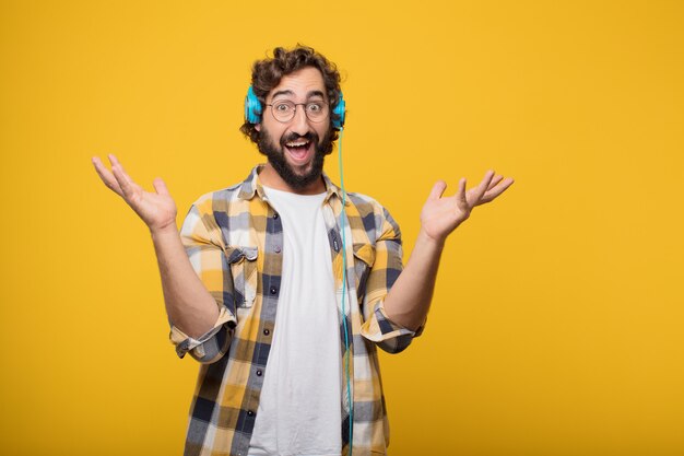 Joven loco loco tonto pose escuchar música con unos auriculares