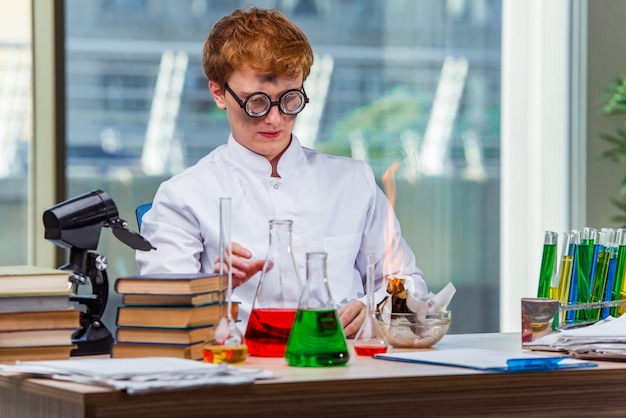 Joven loco químico trabajando en el laboratorio