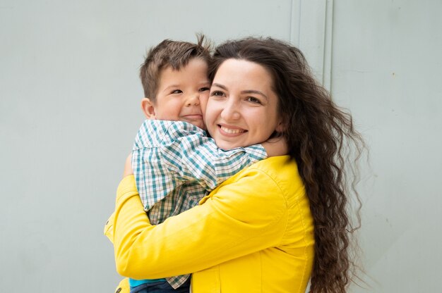 Foto la joven madre abraza al bebé en sus brazos.