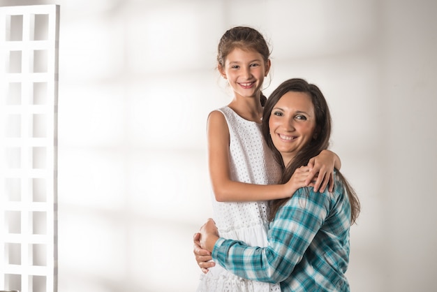 Joven madre abraza a su hija muy positiva