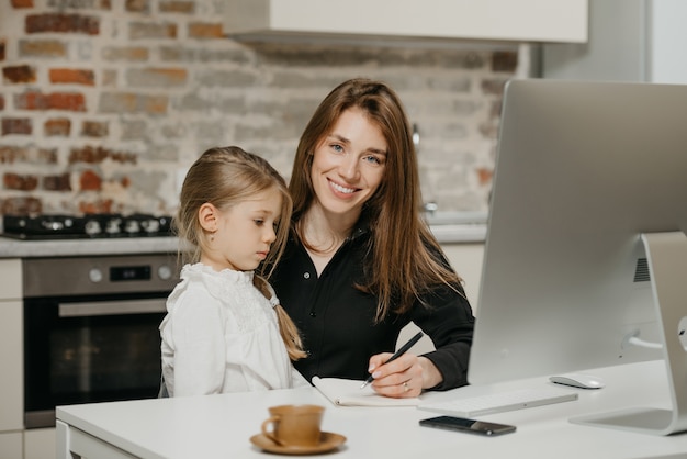 Foto joven madre ayudando a su hija con la tarea