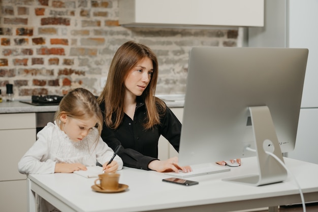 Joven madre ayudando a su hija con la tarea