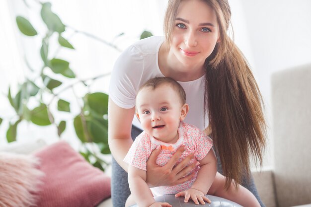 Joven madre bonita trabajando con su pequeño hijo en casa