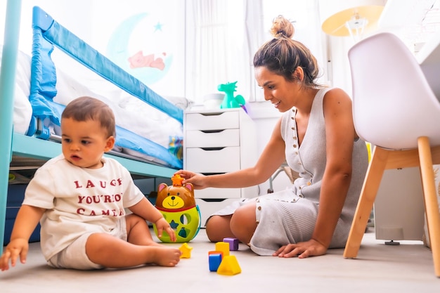 Joven madre caucásica jugando con ella en la habitación con juguetes