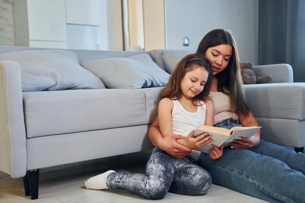 La joven madre caucásica con su hija está en casa juntos