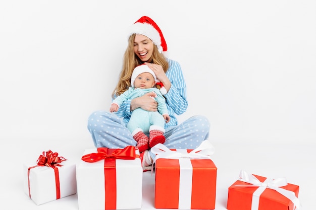 Una joven madre el día de Navidad da un regalo a un niño recién nacido