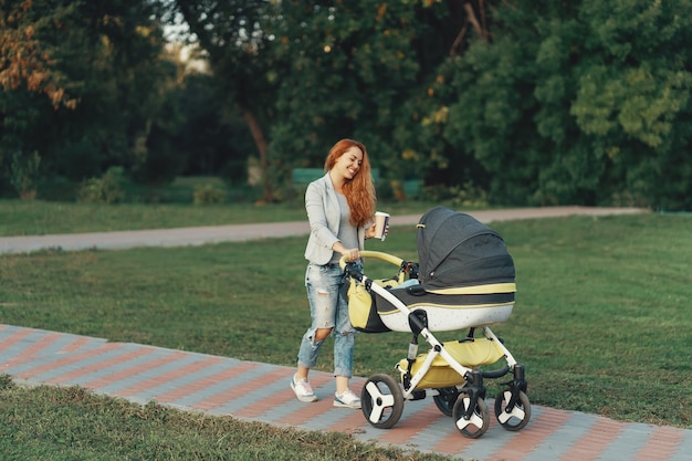 joven madre disfrutando de un paseo en el parque con el bebé