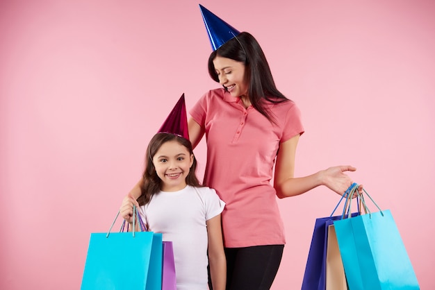 Joven madre e hija en gorras de fiesta