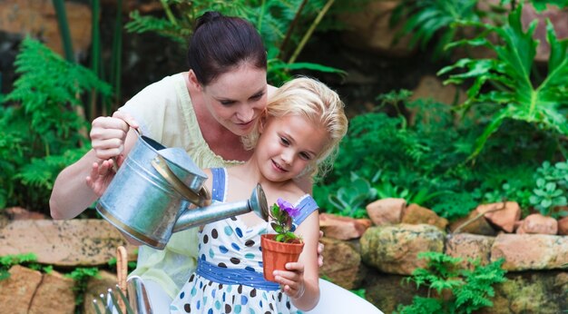 Joven madre e hija plantas de riego